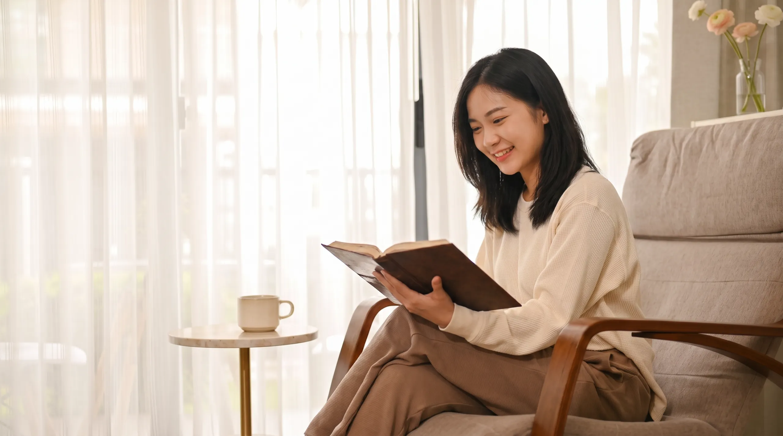 A woman reflecting with a notebook in a calm, sunlit room
